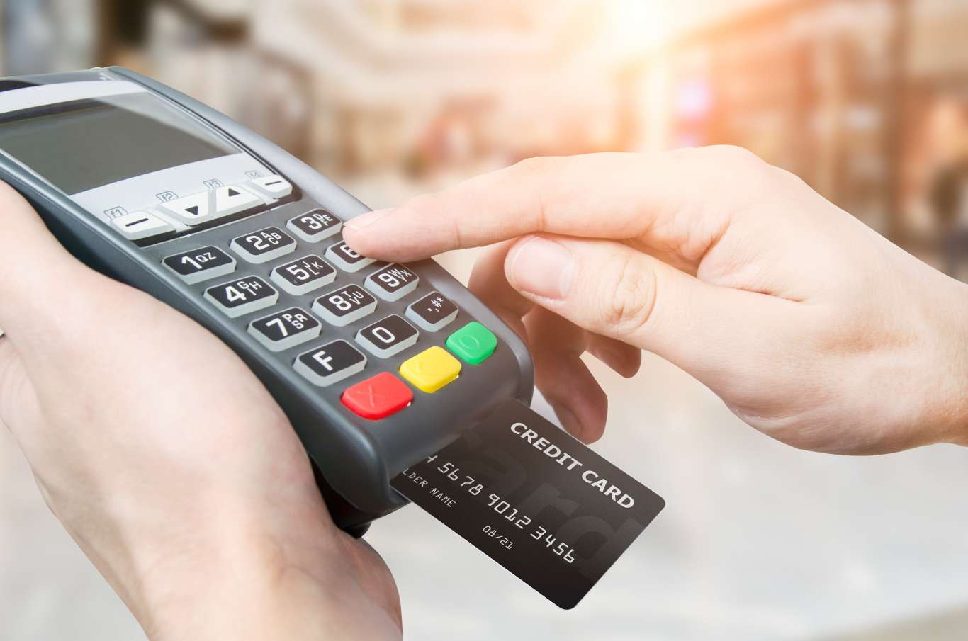 Hand with credit card swipe through terminal for sale in supermarket